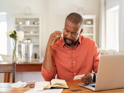 a man on the phone while looking at papers